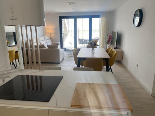 洛斯阿爾卡薩雷斯的住宿－Jacuzzi Penthouse appartement Santa Rosalia Lake & Life Resort Murcia Golf，厨房以及带桌椅的起居室。
