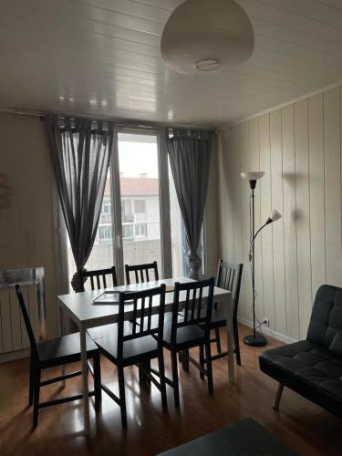 布龍的住宿－Le Parilly- Appartement 3 chambres-Parc Parilly，一间带桌椅和窗户的用餐室