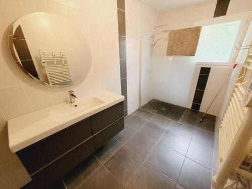 une salle de bain avec un lavabo et un miroir dans l'établissement La Belle des bois, à Pontenx-les-Forges