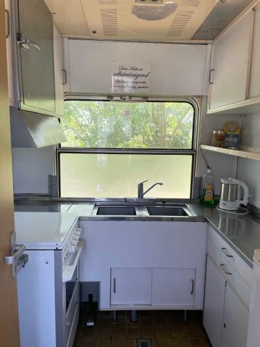 an rv kitchen with a sink and a window at zz_Lokschuppen Pasewalk-Erlebnisübernachtung im Schlafwagen in Pasewalk