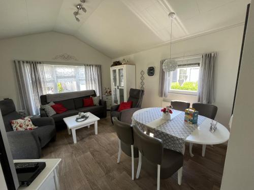 een woonkamer met een tafel en een bank bij Zandput 490 - Camping de Zandput in Vrouwenpolder