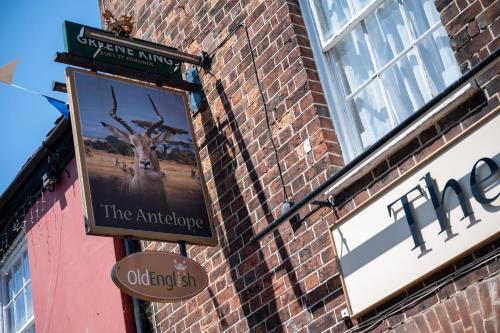 a sign for the antelope on the side of a brick building at Antelope by Greene King Inns in Poole