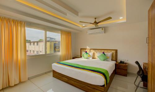 una camera con un grande letto e una finestra di NAWAL MAHAL a Cochin