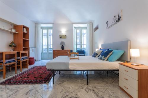 1 dormitorio con 1 cama grande y escritorio en Carlo Alberto House by Wonderful Italy, en Turín