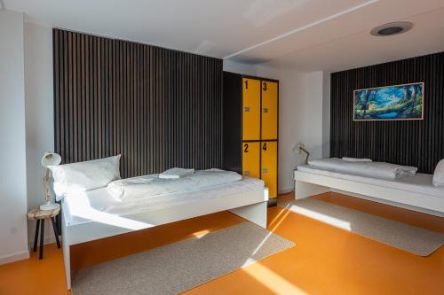 two beds in a room with orange floors at Hostel Mannheim in Mannheim