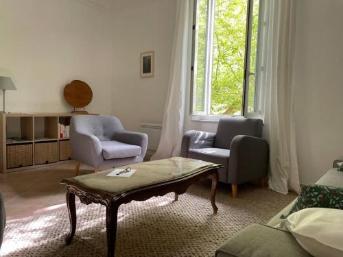 un salon avec deux chaises et une table basse dans l'établissement Jolie maison de ville, à Apt