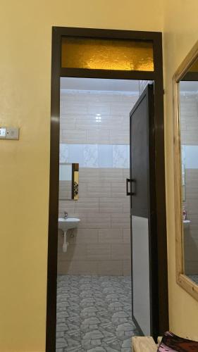 a bathroom with a door leading to a sink at Home Feeling Kilimanjaro in Moshi