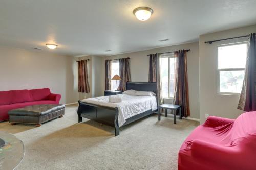 a bedroom with a bed and a red couch at Spacious Vacation Rental Near Utah Lake! in Lehi