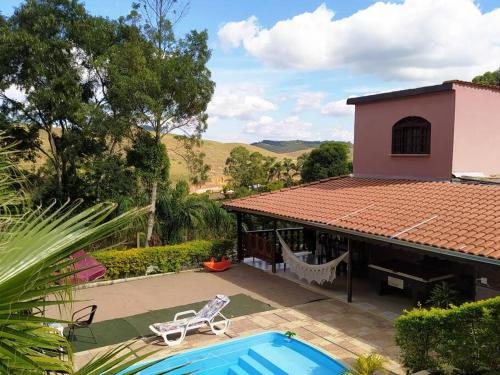 een huis met een zwembad naast een huis bij Casa de campo Domeni rustica e próximo a cidade de Juiz de Fora MG in Juiz de Fora