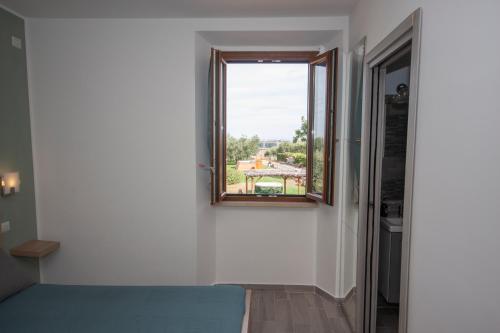 a room with a window with a view of a house at Agriturismo L'Istrice di Giò in Montalto di Castro