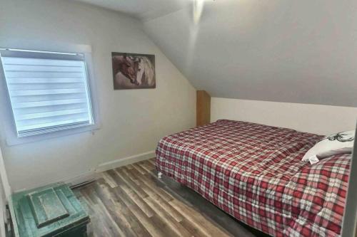 a small bedroom with a bed and a window at Chez Dorance in Saint-Gabriel