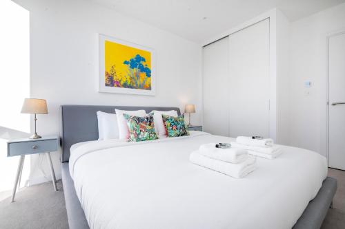 a white bedroom with a large white bed with pillows at Amazing 1BR wbalcony & view, Acton, Smarthost in London