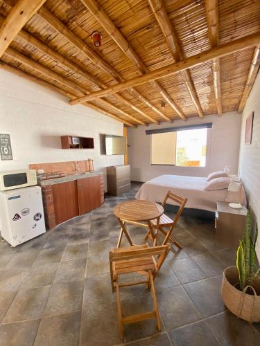 Habitación con cama, mesa y sillas. en Casa Danda Punta Hermosa en Punta Hermosa