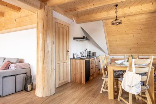 a room with a table and chairs and a kitchen at Dom Tatrzański Ewa Deluxe in Kościelisko