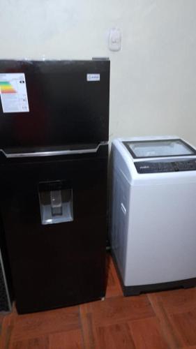 einen Kühlschrank neben einem Toaster und einem Drucker in der Unterkunft Inka Home - Ayacucho in Ayacucho