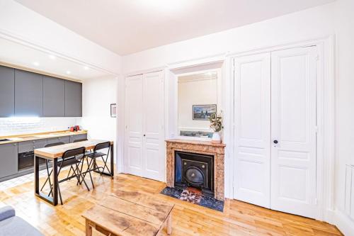 un salon avec une cheminée et une table dans l'établissement Aapartment with character Parquet flooring fireplace - Charpennes, à Villeurbanne