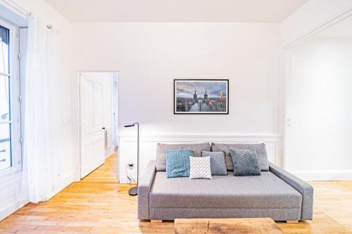 - un salon avec un canapé dans une pièce blanche dans l'établissement Aapartment with character Parquet flooring fireplace - Charpennes, à Villeurbanne