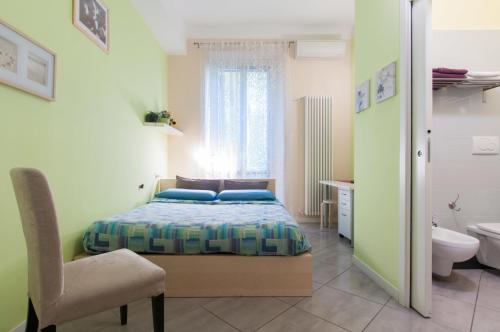 1 dormitorio con 1 cama y 1 silla y baño en Il Cortiletto, en Milán