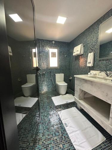 a bathroom with two toilets and a sink and a shower at Dibba Mountain Park Resort in Fujairah