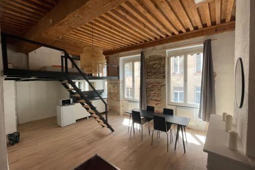a room with a dining table and a loft at Carmélites-Charmant 4 pers-pentes Croix Rousse in Lyon