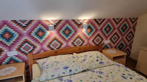 a bedroom with a bed and a colorful wall at Pokoje Gościnne "Adam" in Ustroń