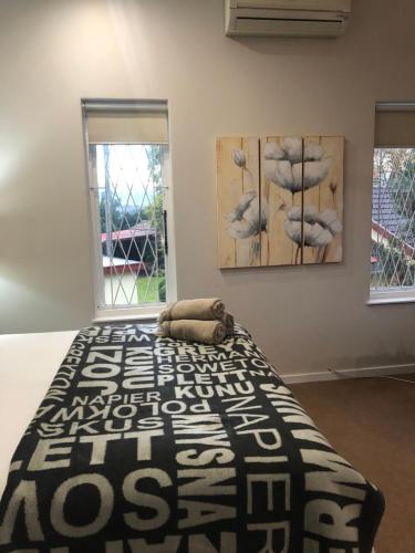 a bed in a room with two paintings on the wall at St John`s Guest House in Pietermaritzburg