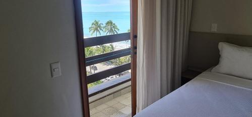 マセイオにあるJATIÚCA SUITES RESORT - FLAT VISTA MARのビーチの景色を望むベッドルーム1室(ベッド1台付)が備わります。