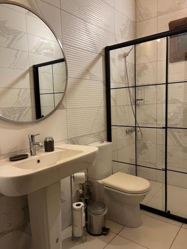 a bathroom with a sink and a toilet and a mirror at Kibala Hotel in Cıralı