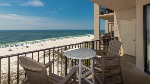 Un balcón con mesa y sillas y una playa. en Phoenix East 1111 condo, en Orange Beach