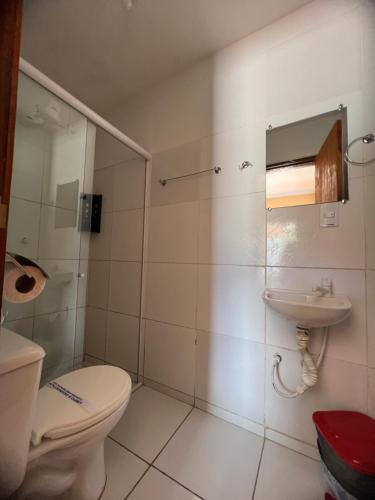 a bathroom with a toilet and a sink at Hotel Pinto Martins in Camocim