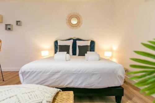 a bedroom with a large white bed with a blue headboard at Le Bohème chic : au coeur du centre historique in Dijon
