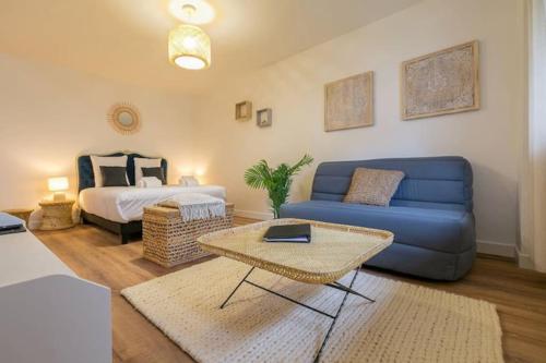 - un salon avec un canapé bleu et un lit dans l'établissement Le Bohème chic : au coeur du centre historique, à Dijon