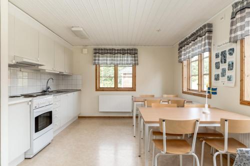 Långvinds Bruk - Vandrarhem في Enånger: مطبخ وغرفة طعام مع طاولة وكراسي