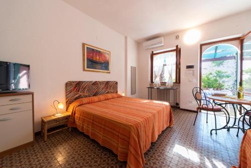 a bedroom with a bed and a table and a tv at Gavila's Residenza Turistico Alberghiera in Porto Azzurro