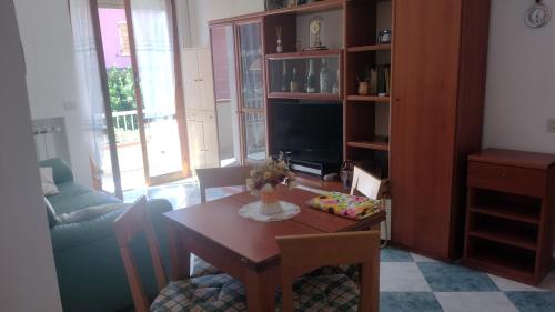 ein Wohnzimmer mit einem Tisch und einem TV in der Unterkunft Casa Smeralda in Ameglia
