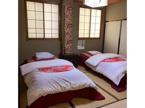 two beds in a room with windows at Ryokan Yuzawa - Vacation STAY 14222v in Yuzawa