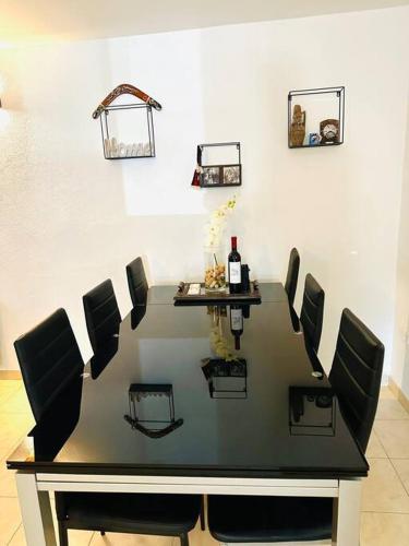 a dining room table with chairs and a bottle of wine at Heart of Brač in Supetar