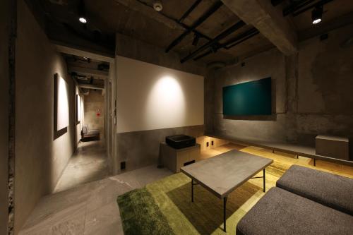 a living room with a couch and a tv on the wall at SHIN kyoto in Kyoto
