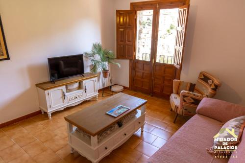 a living room with a couch and a tv at Mirador de Palacios- céntrico con vistas y parking cerca in Albarracín