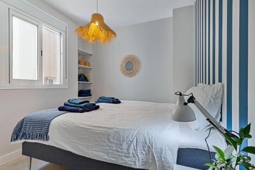 a bedroom with a bed with a lamp and a window at Angelica's Home Fuengirola in Fuengirola