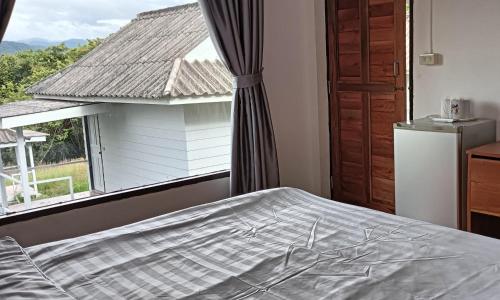 a bedroom with a bed and a large window at Pai sunrise camping resort in Pai