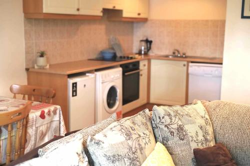a living room with a couch and a kitchen at Long Quay Apartments, Clonakilty in Clonakilty