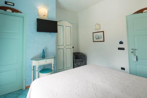 a bedroom with a white bed and a desk at Palazzo Vingius in Minori