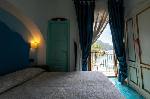a bedroom with a bed and a door to a balcony at Palazzo Vingius in Minori