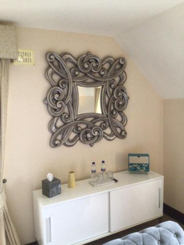 een spiegel aan een muur boven een dressoir in een kamer bij Errew Lodge in Mohill