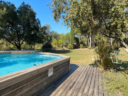 - une piscine sur une terrasse en bois à côté d'une cour dans l'établissement La VILLA, au Cannet-des-Maures