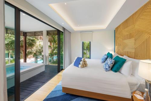 a bedroom with a bed and a swimming pool at Club Wyndham Sea Pearl Phuket in Patong Beach