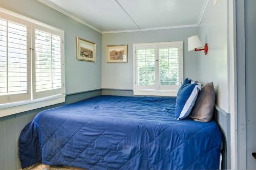 a bedroom with a blue bed with windows at Walk to Beach Catalina Gem with Deck! in Avalon