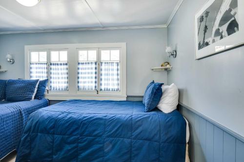 Charming Catalina Gem with Deck Walk to the Beach! في أفالون: غرفة زرقاء بسريرين ونوافذ