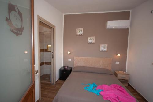a bedroom with a bed with a pink shirt on it at Agriturismo L'Istrice di Giò in Montalto di Castro